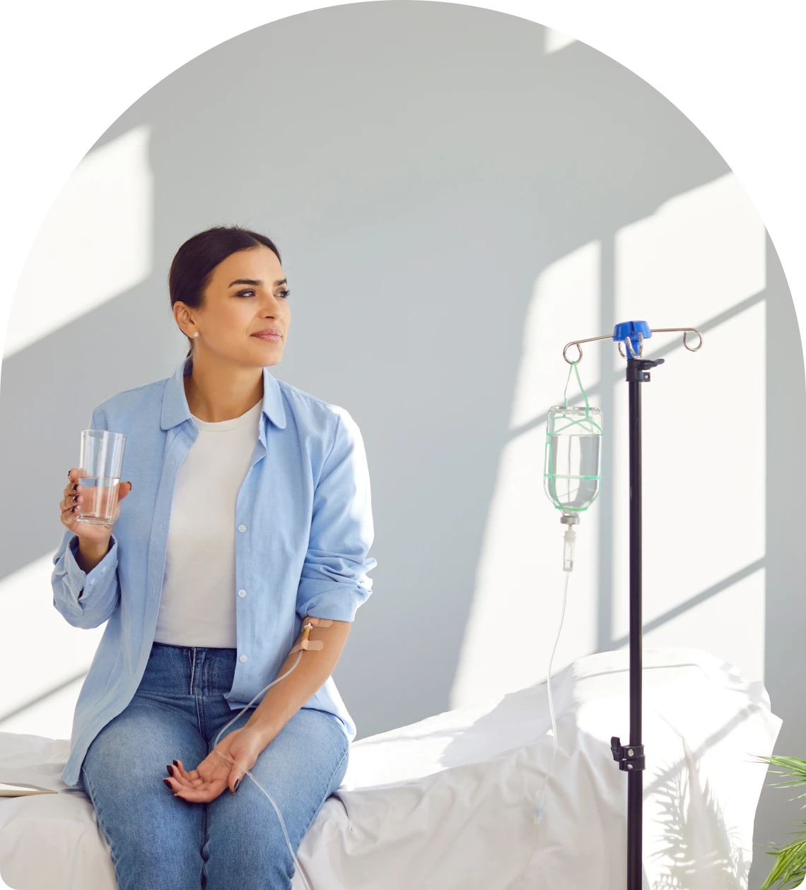 Woman sitting with IV and water glass